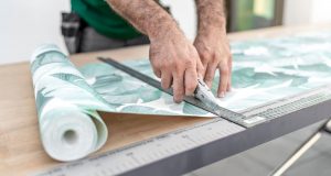 Ein Mann schneidet Tapete