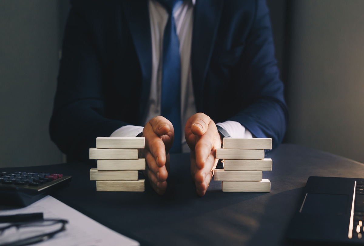 Ein Paar Hände teilt Bauklötze in zwei Stapel